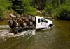 A Bighorn Sports guided tour truck crossing the Red River on a mountain tour.