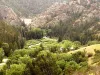 The Cimarron River winding through Cimarron Canyon, with Eagle Nest Dam visible in the distance at the head of the canyon.