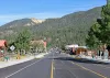 East Main Street in Red River, New Mexico, lined with shops and parked cars beneath forested slopes, in a June 2026 photograph.