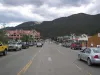 Main Street in Red River, New Mexico looking northwest, with the Lifts West lodge on the left and the forested ski mountain rising behind town.