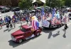 A vintage red pickup leads a patriotic float down Main Street during Red River's Fourth of July parade.
