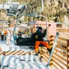 A snowboarder loads the Platinum Chair at Red River Ski and Summer Area above the town of Red River.