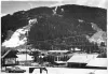 A black-and-white photograph, circa 1980, of Red River's ski slopes rising above the town and the All Season Mall.
