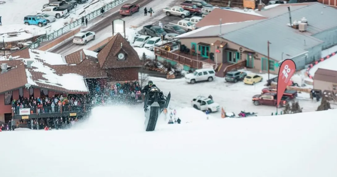 A snow bike rider goes airborne at the base of Red River Ski Area during Race the Face.