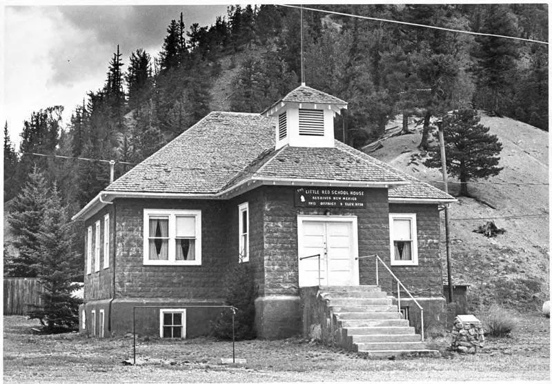 The Little Red School House in Red River in a black-and-white photograph from about 1980.
